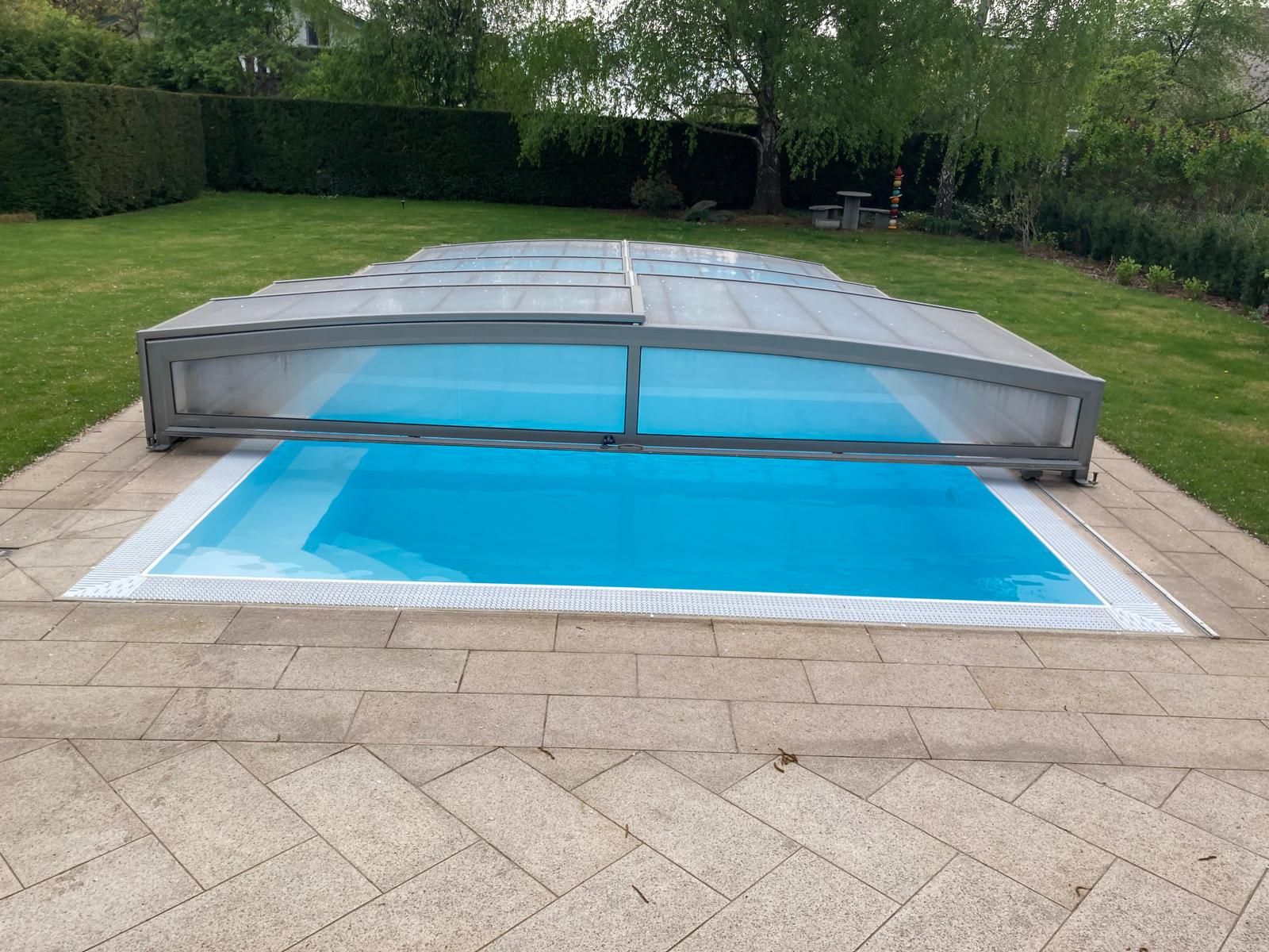 Strahlend sauberer Pool mit klarem blauen Wasser und Überdachung
