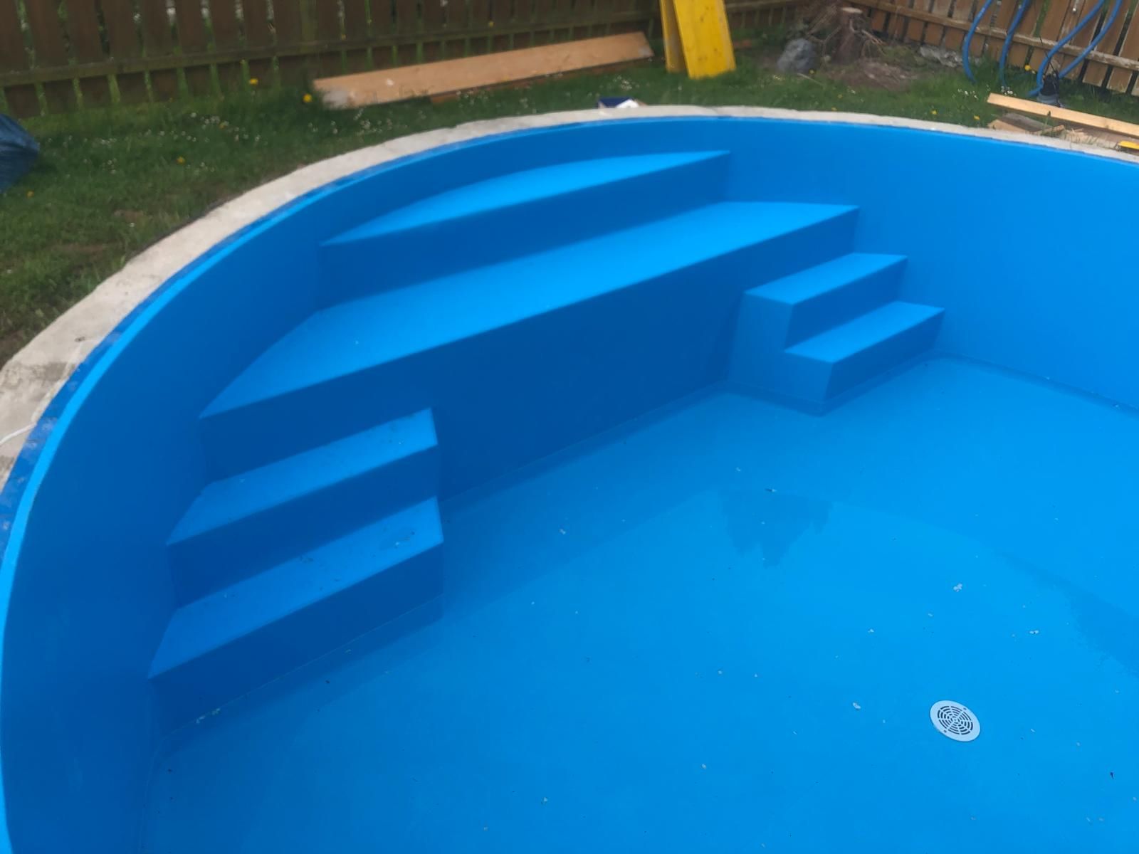 Frisch gereinigtes Rundbecken mit blauer Folie und Treppe