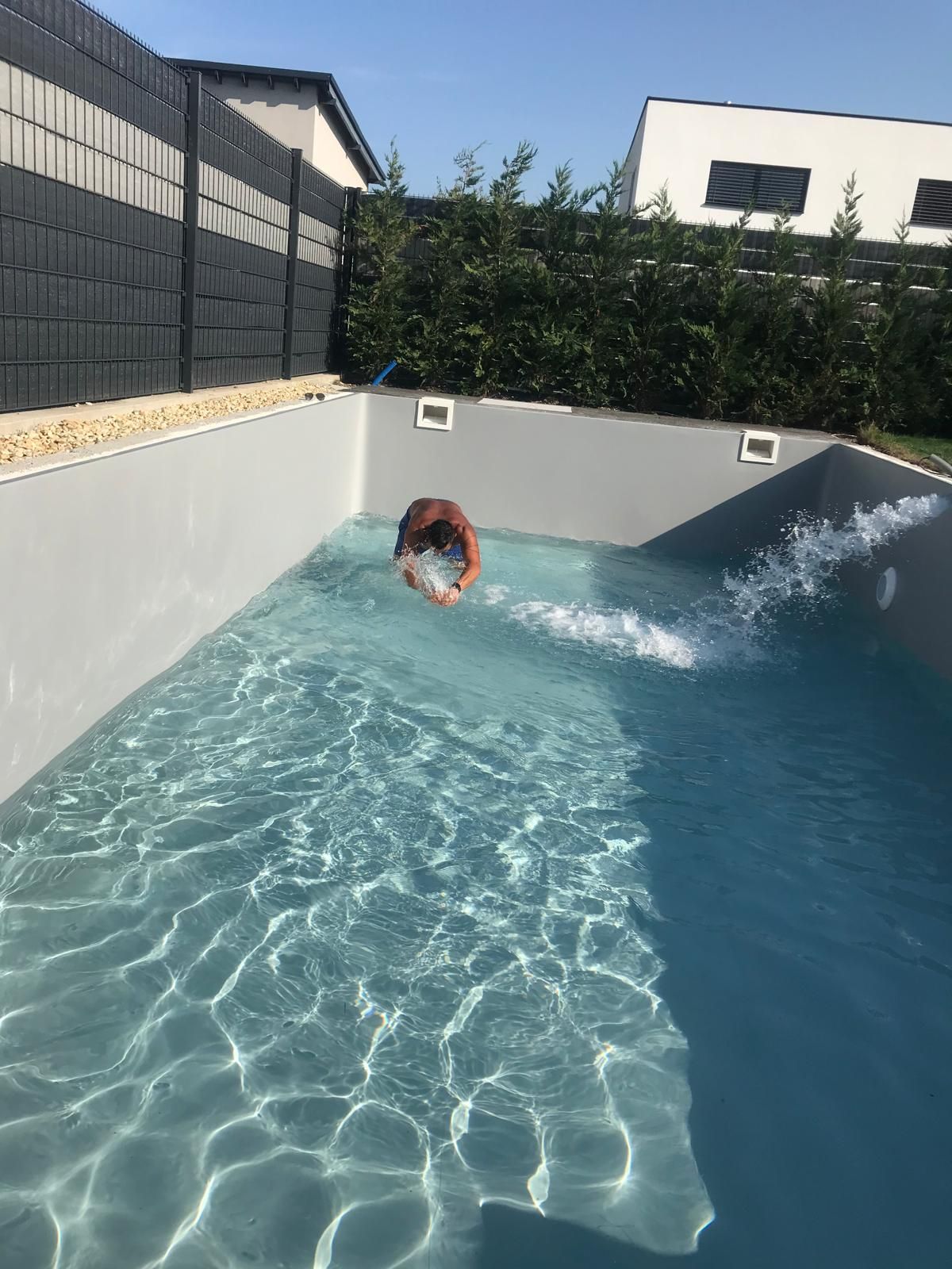 Frisch befüllter Pool beim Saisonstart mit laufenden Einlaufdüsen